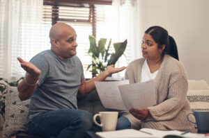 Shot of a young couple having an argument while going over paperwork at home