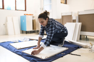 Low angle view of a smiling woman building a kitchen cabinet