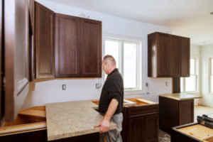Contractor installing a new laminate kitchen counter top Kitchen more functional with a sink, cooktop,