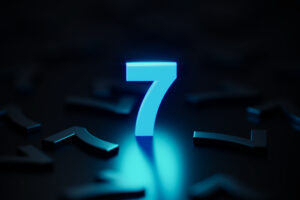 Blue number seven glowing amid black number sevens on black background. Horizontal composition with copy space.