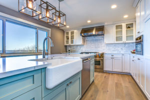 Beautiful kitchen room with green island and farmhouse sink.