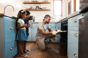 Shot of a young man baking at home with his two young kids